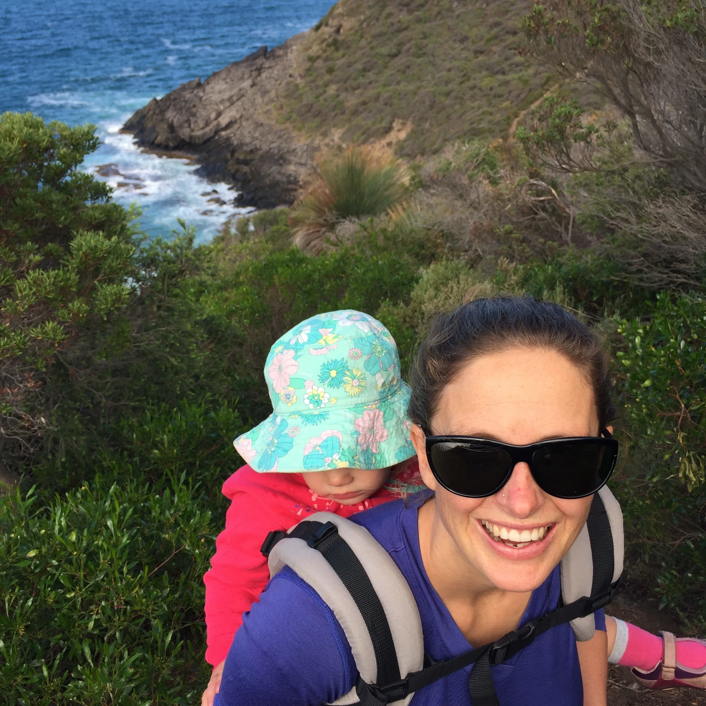 Emma hiking with a child on her back.