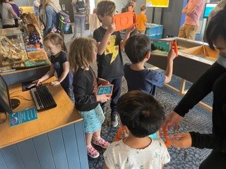 Several students engage with items at the Marine Discovery Centre at an opening day