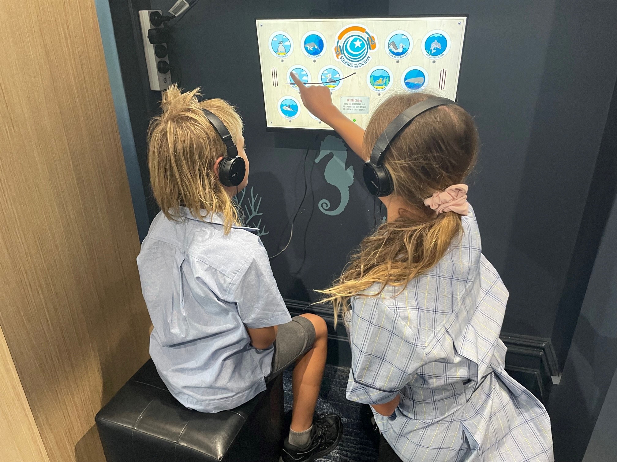 Two children at the Marine Discovery Centre pointing at a new interactive display