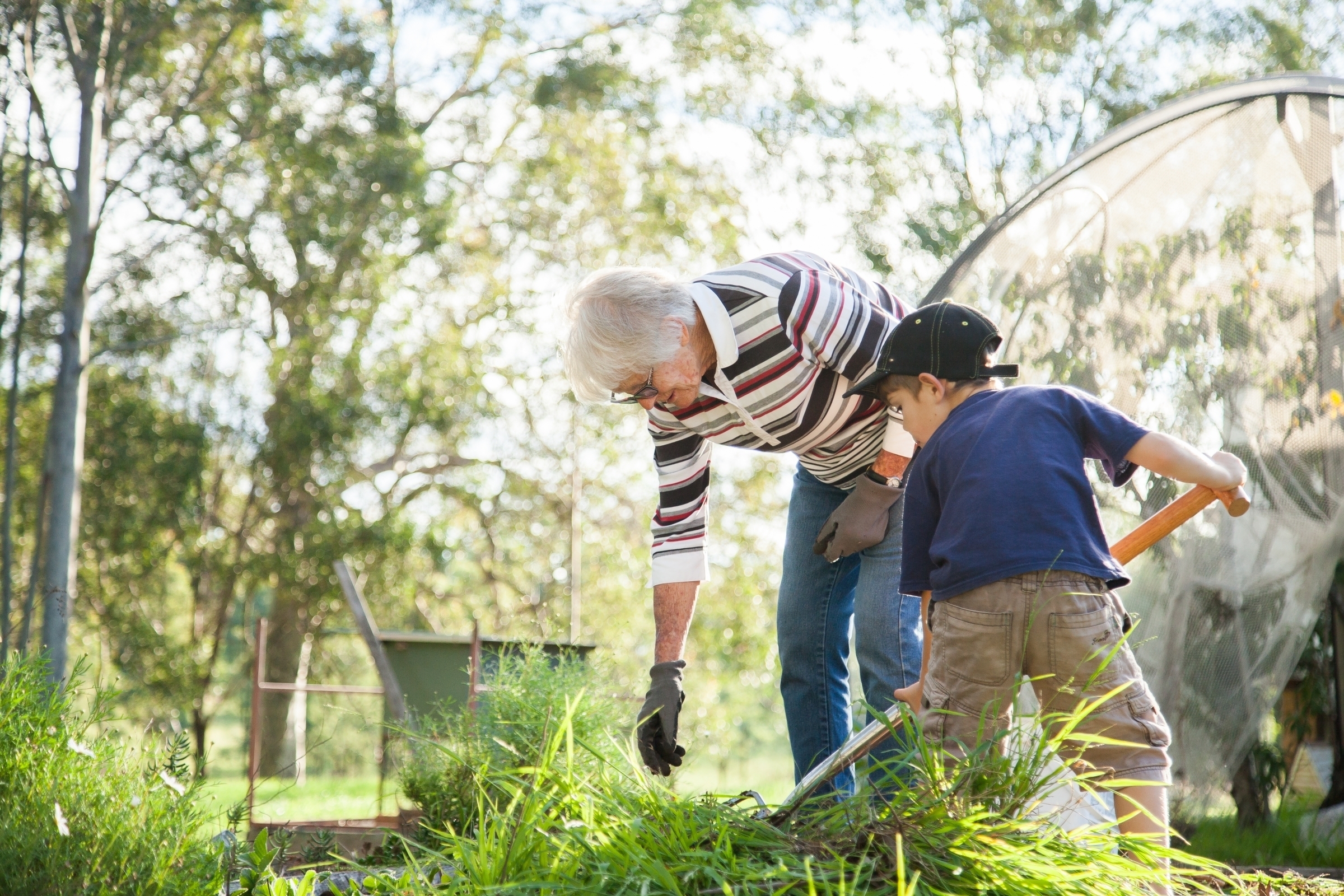 Woman and her grandson weeding their garden