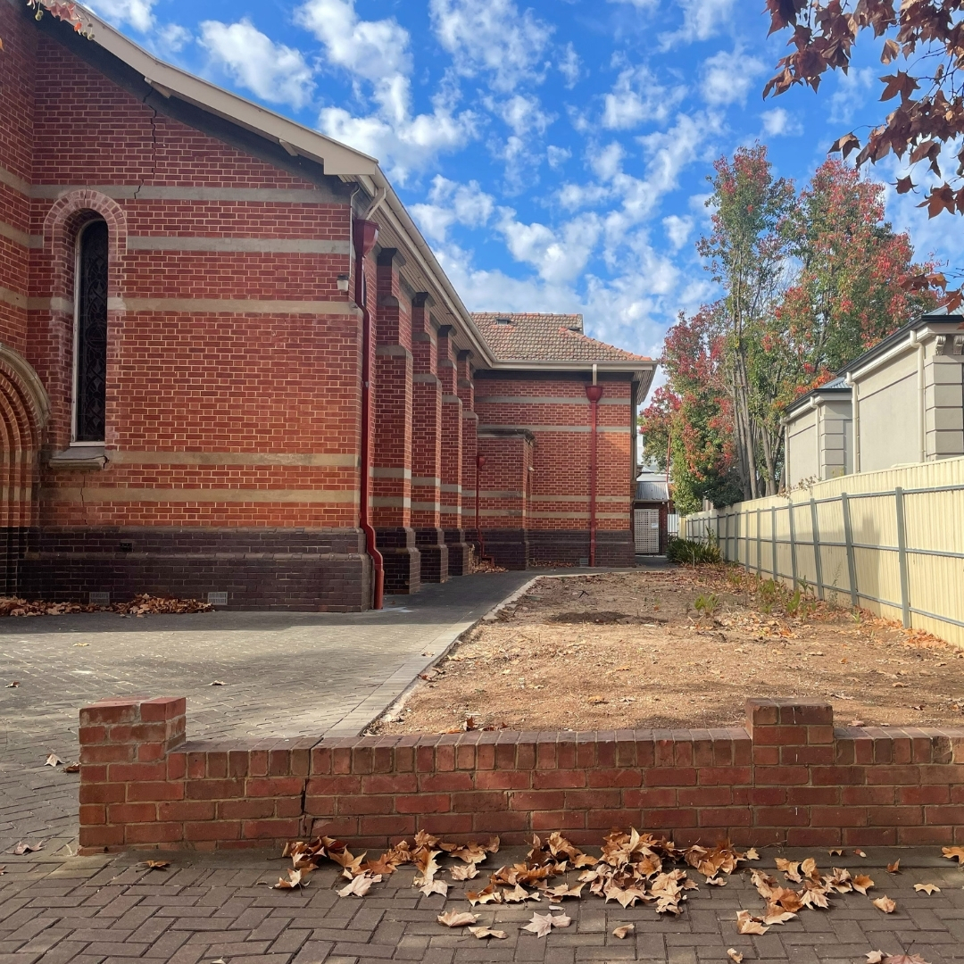All Souls Church front garden patch close up. It has been cleared for planting next to the church building.