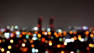 A city view lit up by light pollution at night time, with not a single star in the sky.