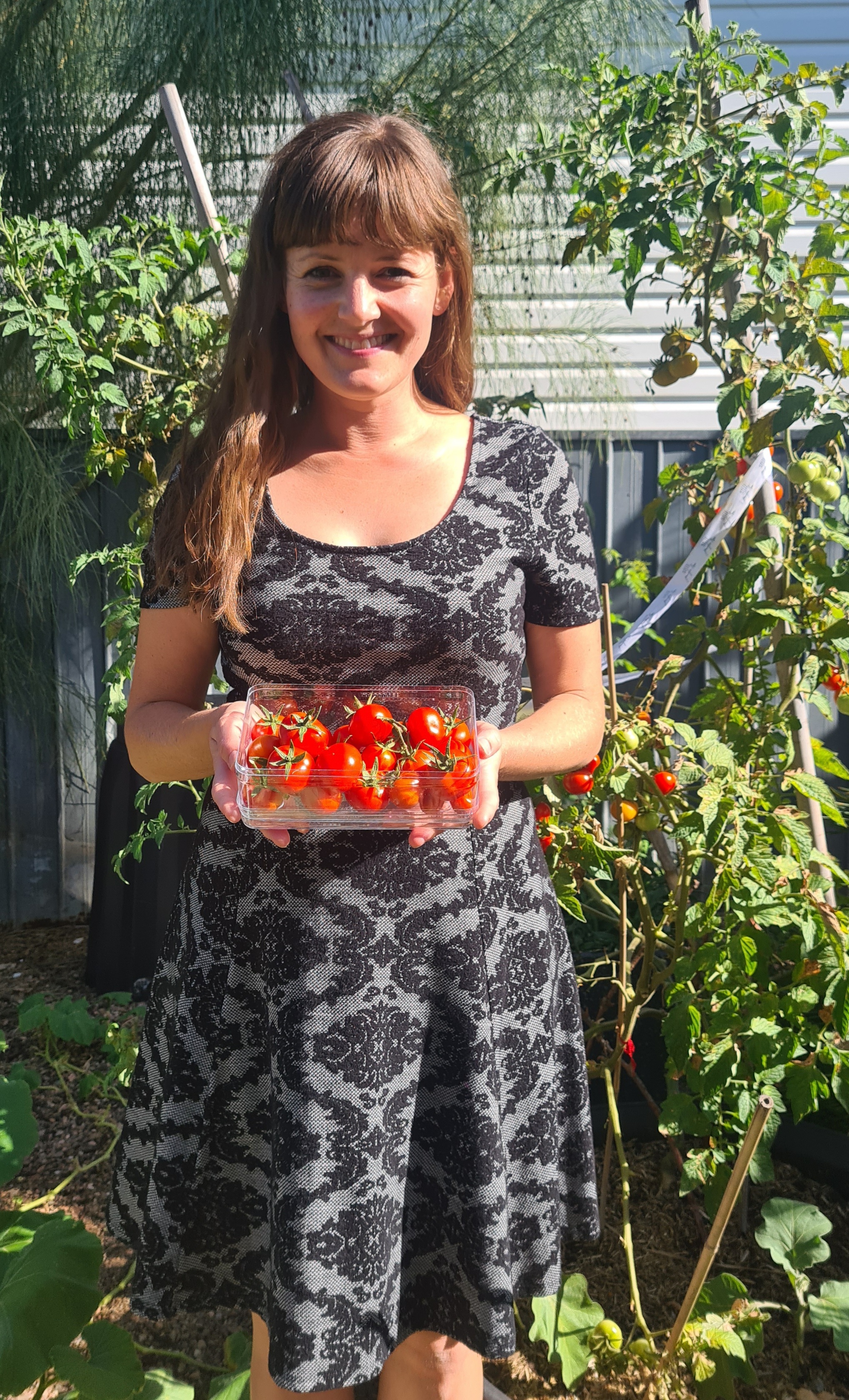 Laura Carrington holding homegrown tomatoes.